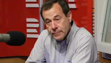 Muž mluví do mikrofonu v rozhlasové studii.