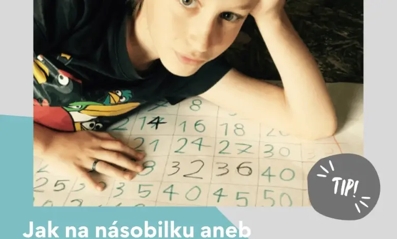 Dětský chlapec píše tabulku násobení na papíře.