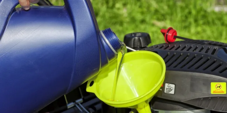 Nalévání ole z modré nádury do žlutého lejna na motor.