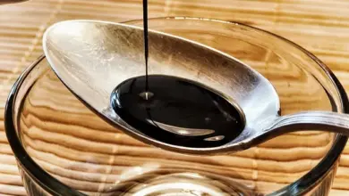 Soy sauce pouring into spoon and bowl