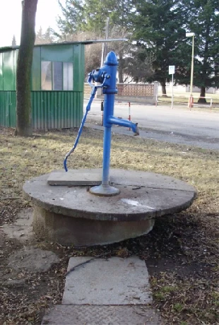 Modrá ruční čerpadlo studně venku na betonu.