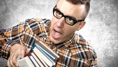 Muž s brýlemi drží knihy, symbolizuje studium psychologie.