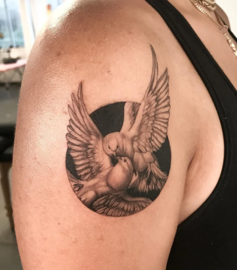 Tattoo of two doves kissing in a circle