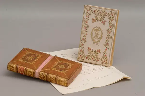 Stará kniha s listem, evokující historický kontext.