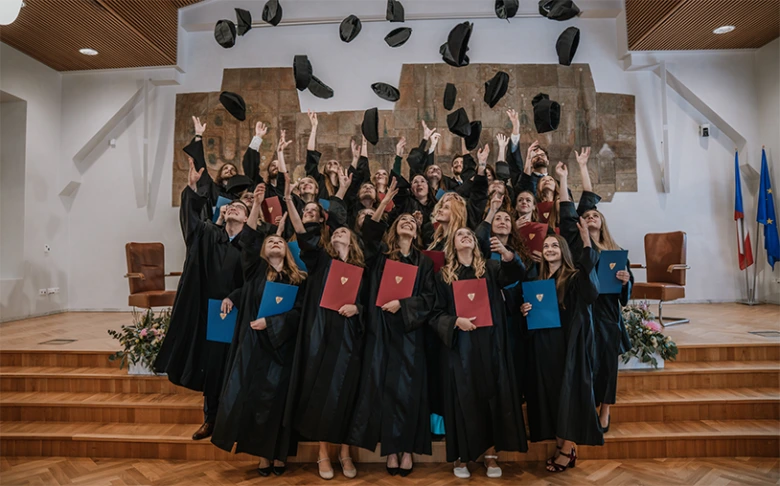 Absolventi psychologie slaví úspěch po ukončení studia.