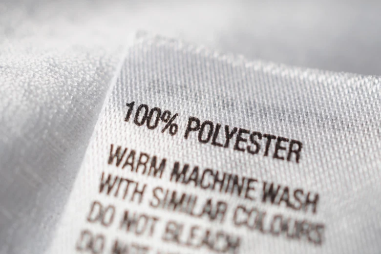 Bližší záběr na štítek s textem 100 % polyester.