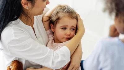 Mother comforting crying toddler