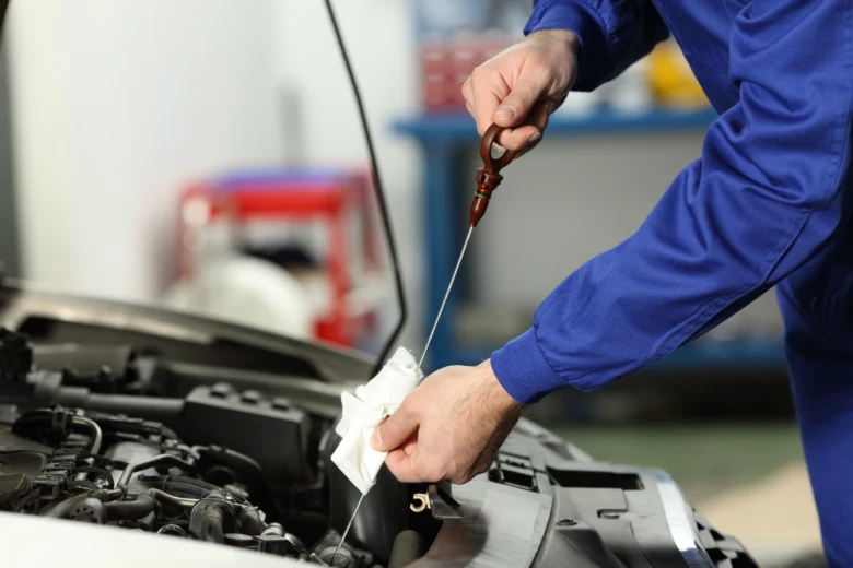 Mechanik kontroluje hladinu motorového oleje pomocí lžíce.