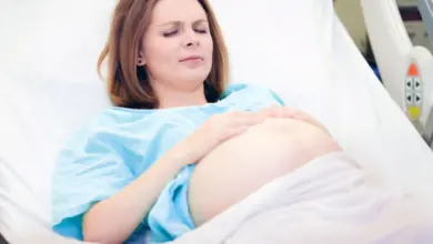 Těhotná žena v nemocničním lůžku s bolestivými kontrakcemi.