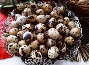 Mnoho křepelčích vajec v dekorativní skleněné míse.
