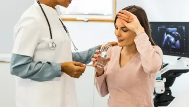 Těhotná žena s lékařem v ordinaci před ultrazvukovým přístrojem.