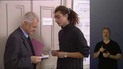 Muži v kanceláři předávají dokumenty při formálním jednání.