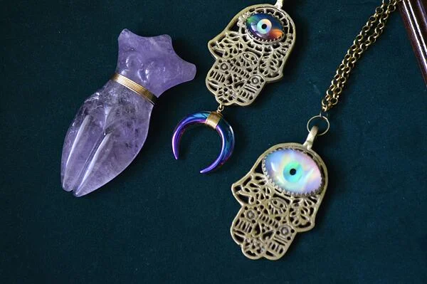 Dvě amulety ruky Fatimy s okem zla na tmavém pozadí