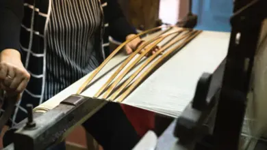 Kovářka na tkalcovském stavu upravuje vlákna pro určení líce látky.