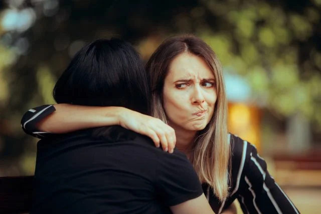Woman hugging person with pouty face