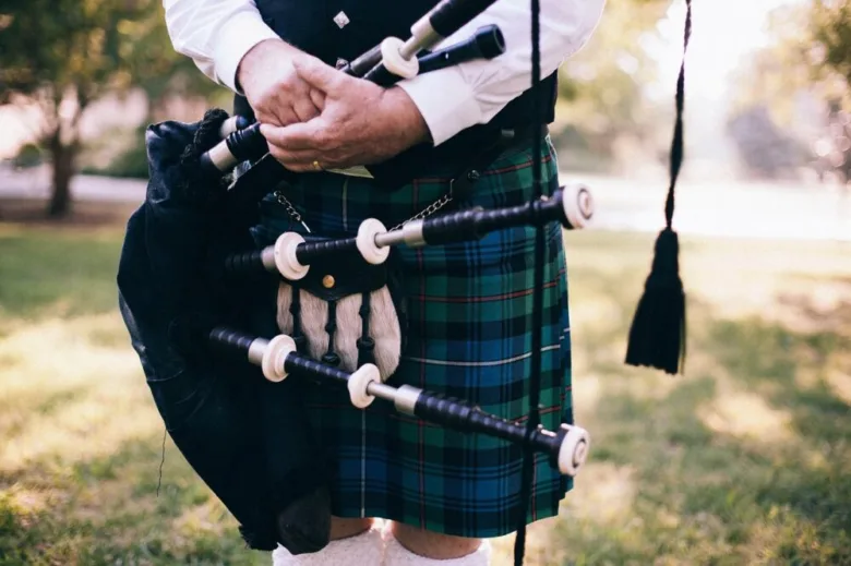 Man playing bagpipes in kilt