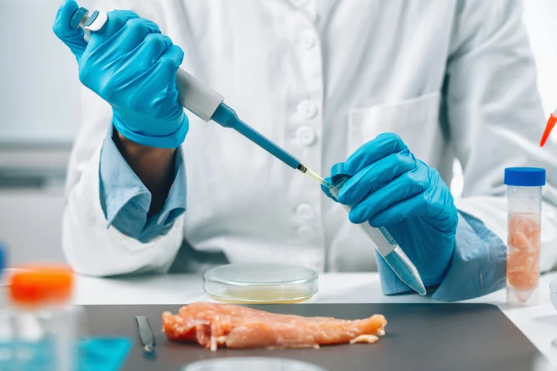 Vědec zkoumá vzorek masa v laboratoři pomocí pipety.