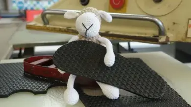 Malá vlněná ovečka sedí na podrážce boty.