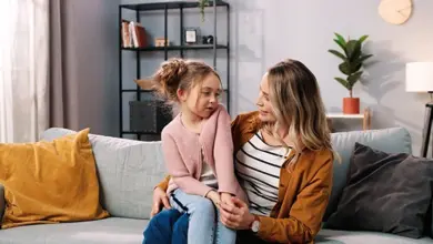 Mother and daughter talking on sofa