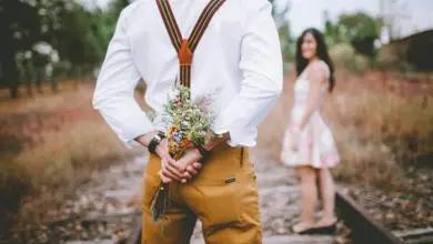 Couple with bouquet behind back