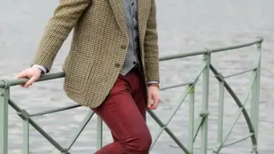 Muž v typickém stylu hipstera stojí u řeky.