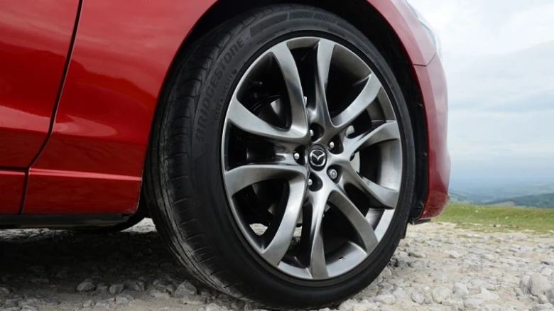 Koleje automobilu s radiálními pneumatikami na štěrkové cestě.