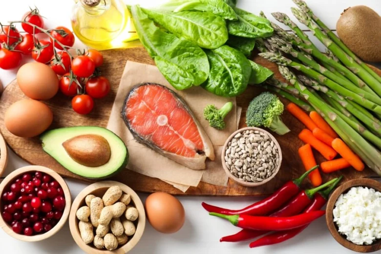 Různé potraviny bohaté na vitamín B: losos, vejce, avokádo a zelenina.