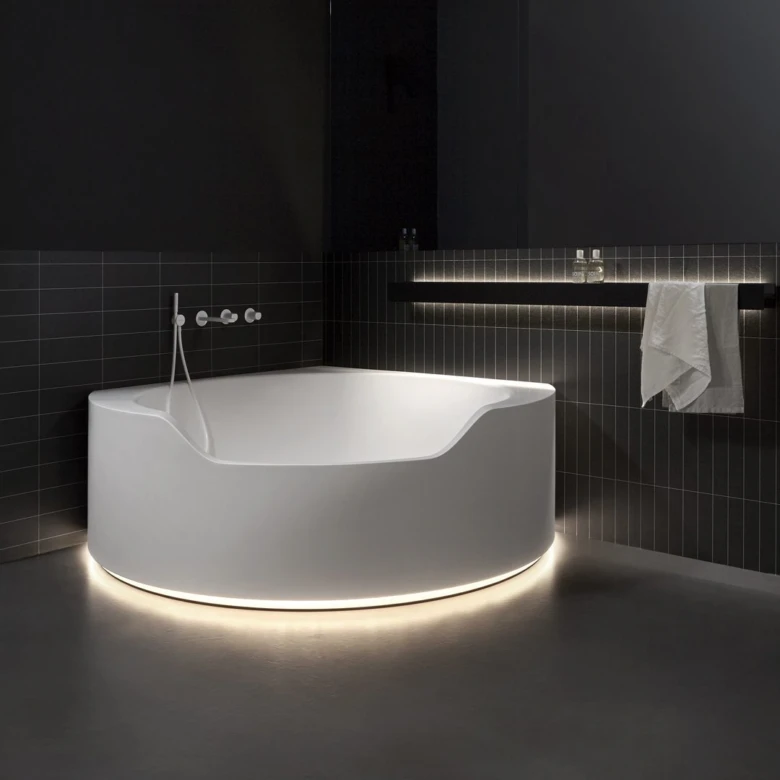 Moderní bílá freestanding vana v tmavém koupelnovém interiéru.