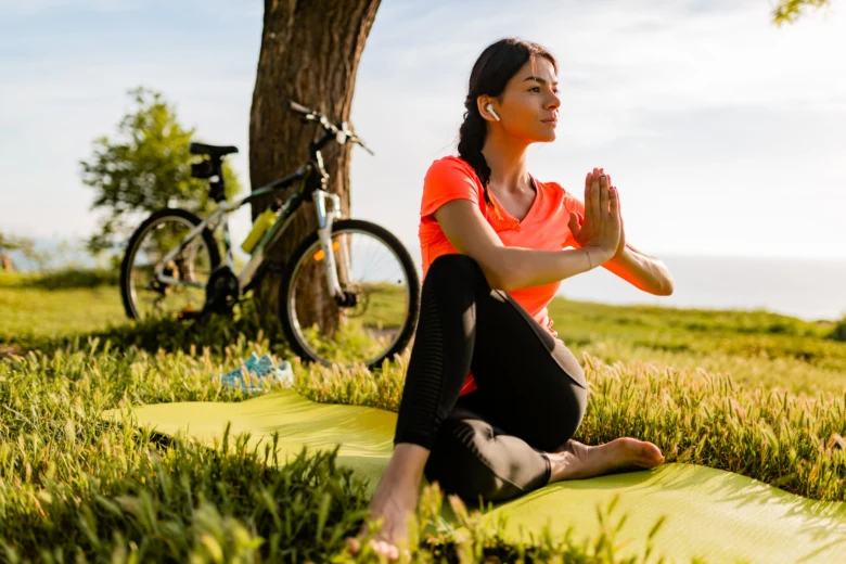 Woman doing yoga outdoors with bike