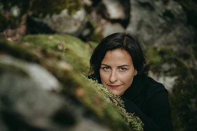 Žena v přírodě mezi mechem na skále.