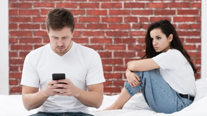 Man and woman on bed ignoring each other