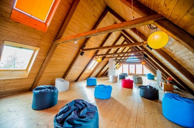 Kouzelná dřevěná ložnice s barevnými pytlíky pro relaxaci.