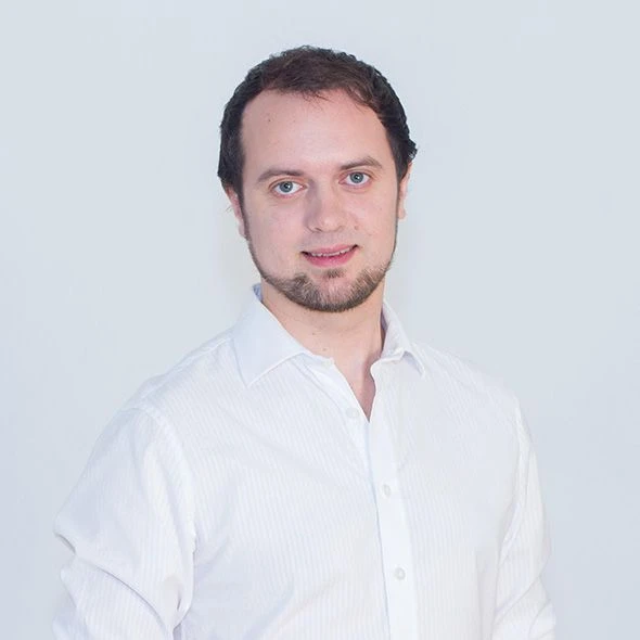 Muž v bílé košili na neutrálním pozadí pro článek o ramenní impingement syndromu.