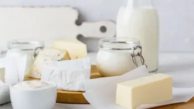 Sýry, mléko a další mléčné výrobky na dřevěném podnosu.