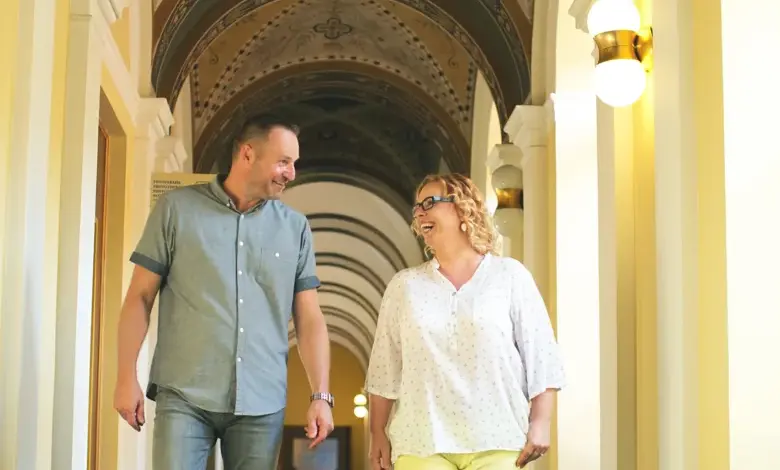 Muž a žena procházejí koridorem lázní v pohodlném oblečení.