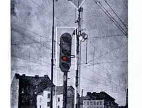 Železniční signál s červenou světelnou částí na koleji.
