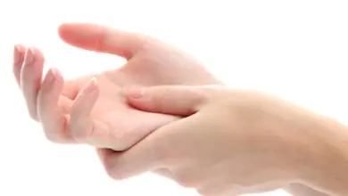 Ruka masíruje dlaň druhé ruky na bílém pozadí.