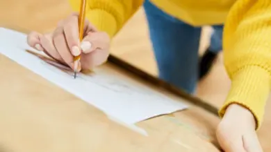 Osoba kreslí tužkou na papíře při práci s různými styly.
