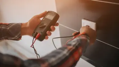 Měření napětí v zásuvce multimetrem při práci s elektrickým obvodem.