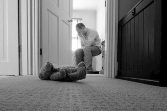 Man sitting with teddy bear