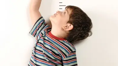 Chlapec měří svou výšku na růstové tabuli.