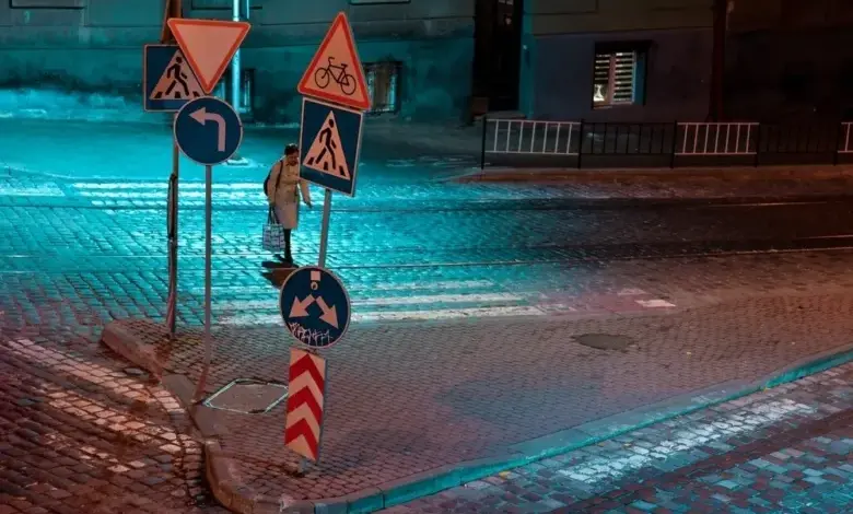 Noční scéna s dopravními značkami na křižovatce v Praze.