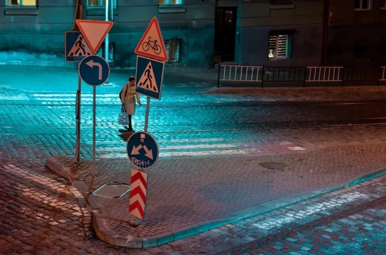 Noční scéna s dopravními značkami na křižovatce v Praze.