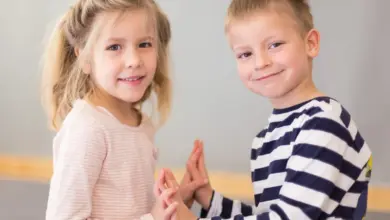 Dvě děti se usmívají a drží si ruce.