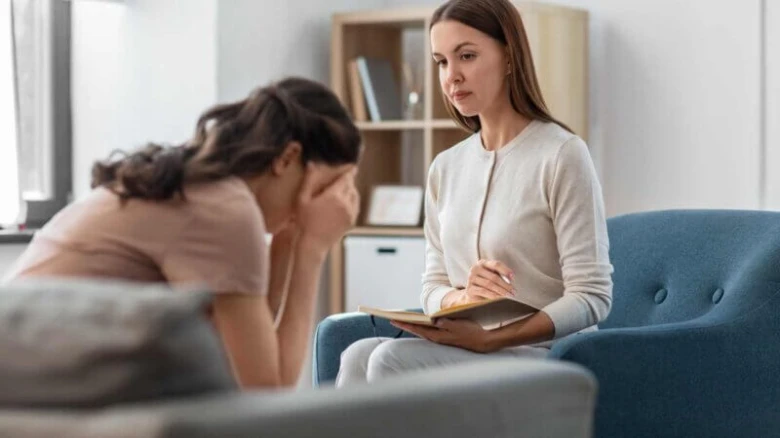 Psychologka naslouchá klientce v terapeutickém rozhovoru.