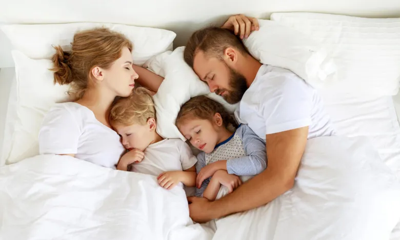 Family sleeping in bed