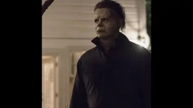 Michael Myers z filmu Halloween stojí venku v noci.