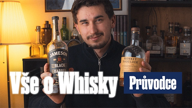 Muž drží dvě lahve whisky před regály s dalšími lihovinami.