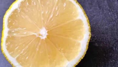 Čerstvý citron nakrájený na polovinu s viditelnými segmenty.