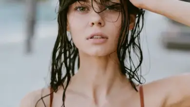 Žena s mokrou vlasy se hřebe na prstu.